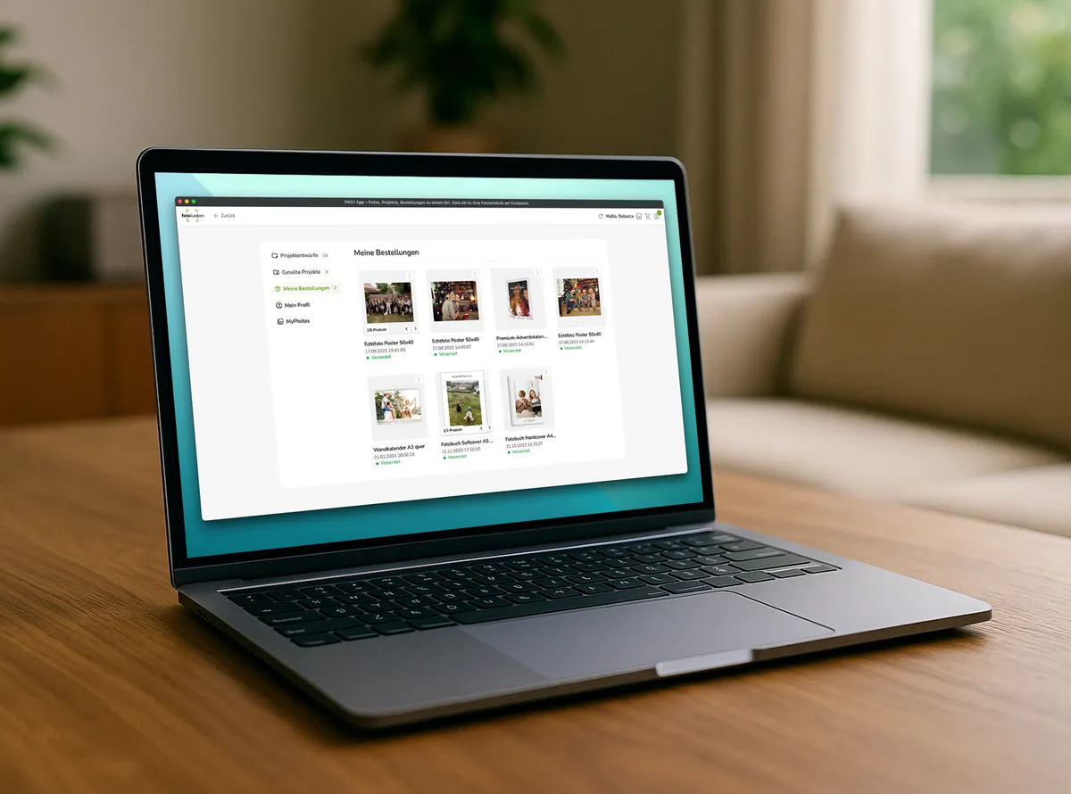 Laptop steht auf einem dunklen Holztisch und zeigt eine Übersicht von Fotoprodukt-Projekten innerhalb eines Kundenkontos